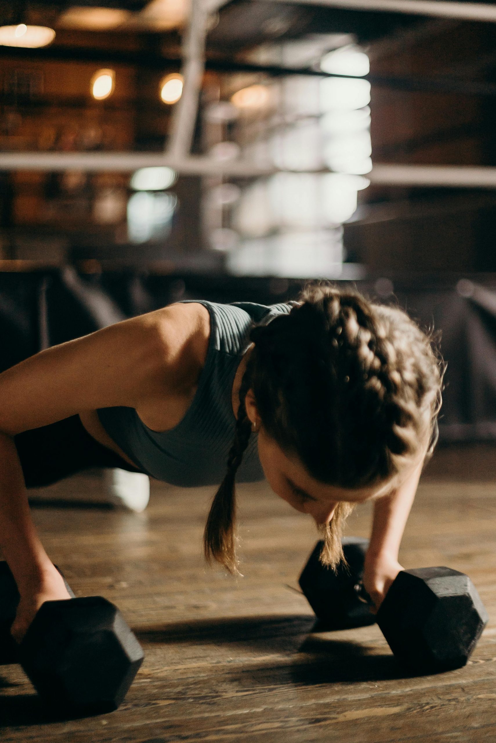 Man and woman performing medicine ball exercises in a gym setting.
