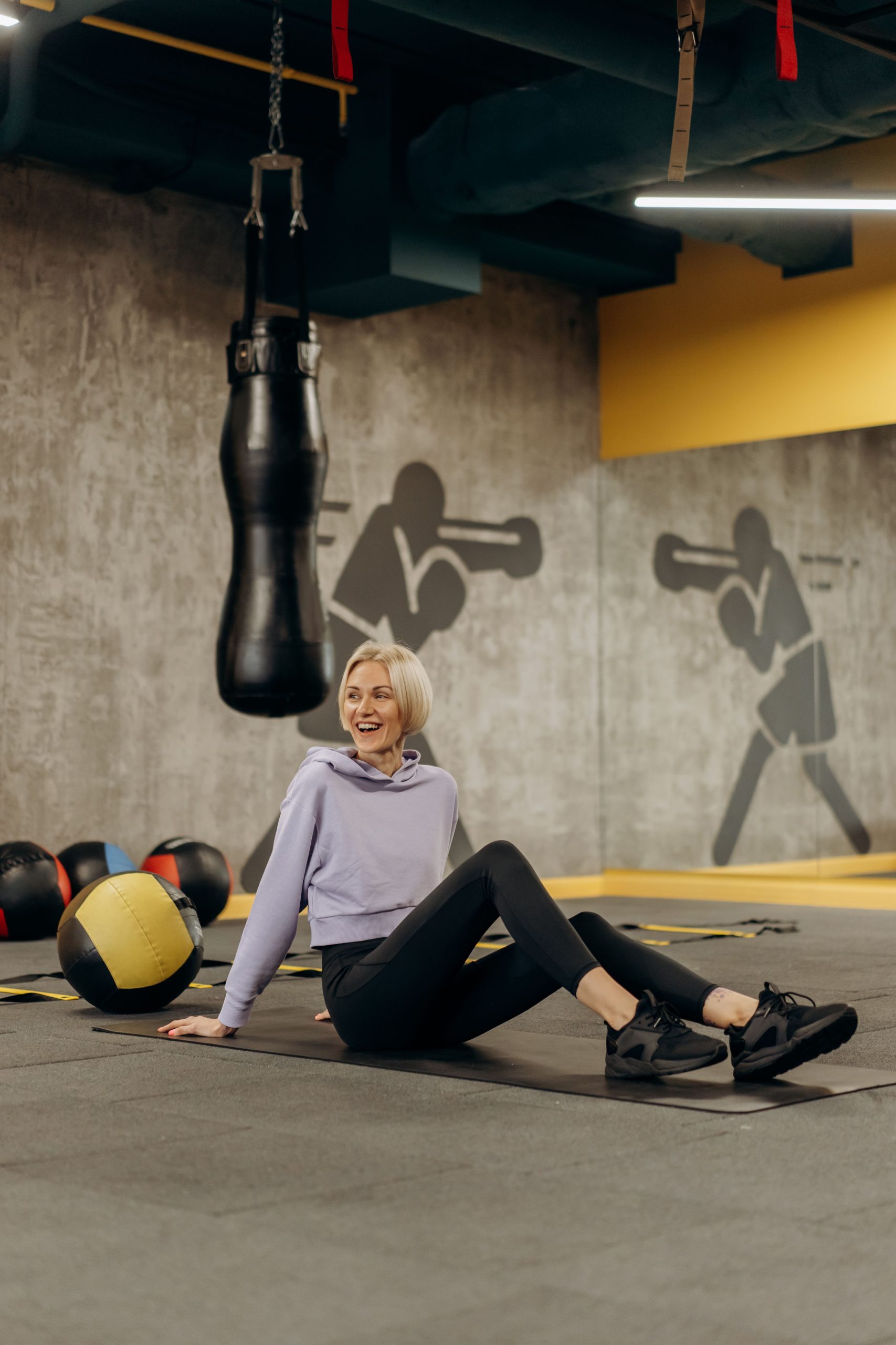 Man and woman performing medicine ball exercises in a gym setting.